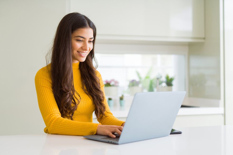 Woman on laptop writes and formats her resume to get it past the ATS