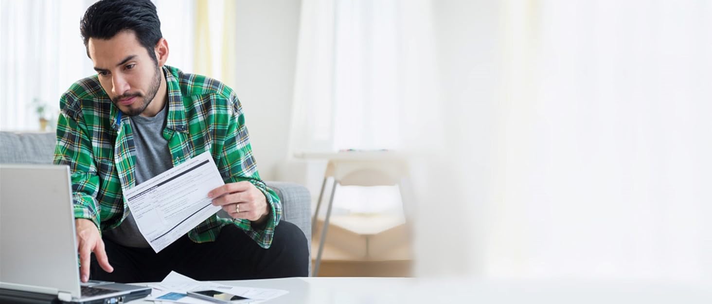 Young man preparing taxes on his laptop