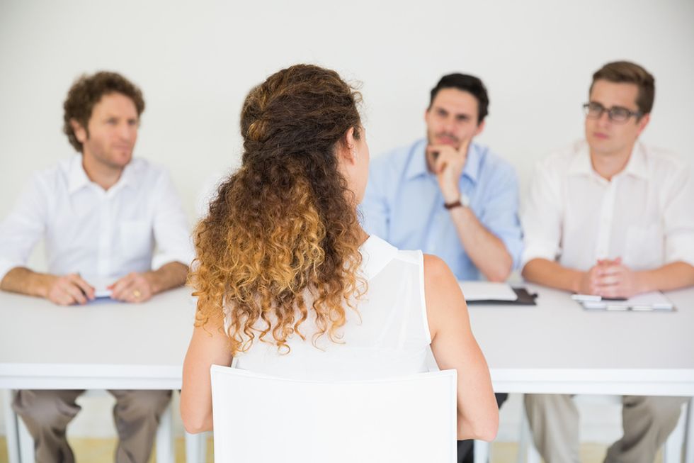 A job applicant answers a question from a panel of interviewers