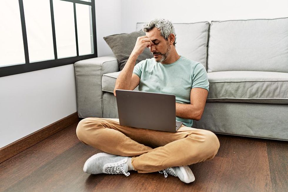 Man on laptop stressed about finding a new job