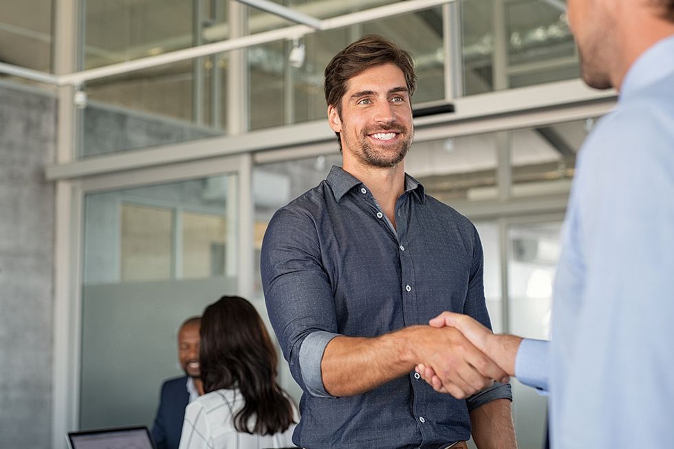 Man shakes the hand of a hiring manager during his job search