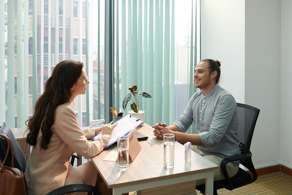 Man smiles during a job interview as he answers questions