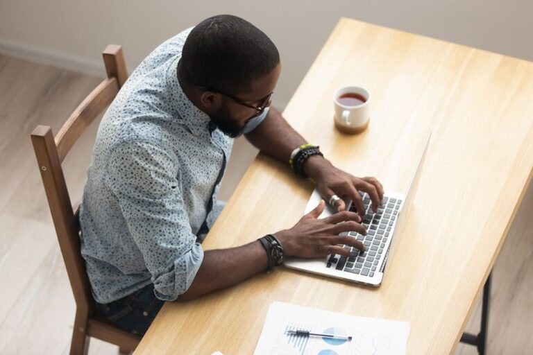 Man writing a cover letter on his laptop during his job search