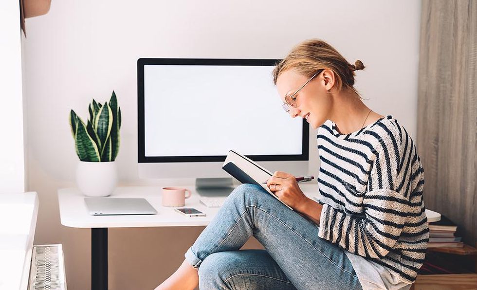 Woman takes notes and writes down career goals she wants to achieve