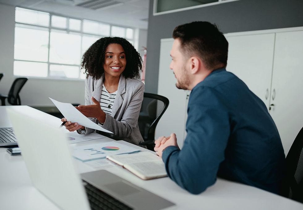 Woman who chose a career in media talks to a coworker