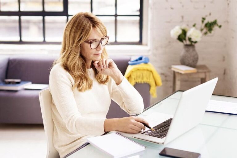 Employer on laptop reviews a candidate's social media accounts during the hiring process