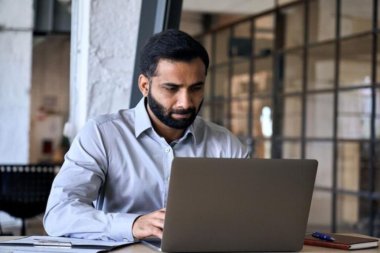 Man on laptop uses marketing tools and strategies to navigate compliance